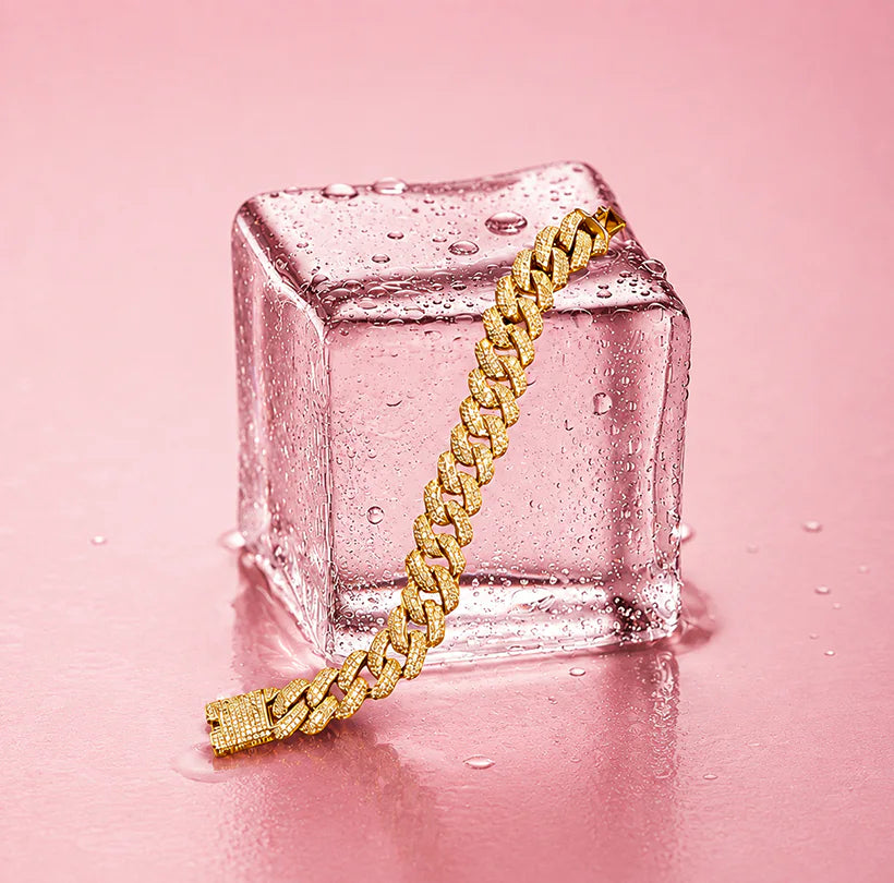 Gold chain bracelet draped over a pink crystal cube